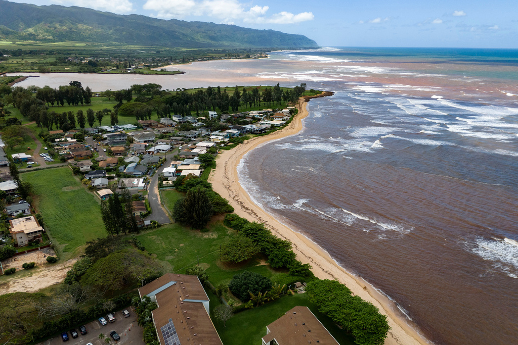 An aerial view shows discolored water along the North Shore coastline, Tuesday, March 24, 2026, in Haleiwa, Hawaii. (AP Photo/Mengshin Lin)