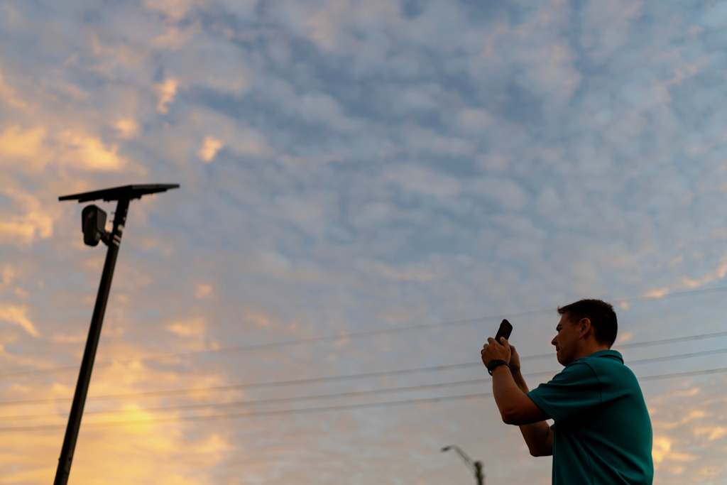 Alek Schott photographs a Flock Safety license plate reader in his neighborhood, Thursday, Oct. 16, 2025, in Houston. (AP Photo/David Goldman)