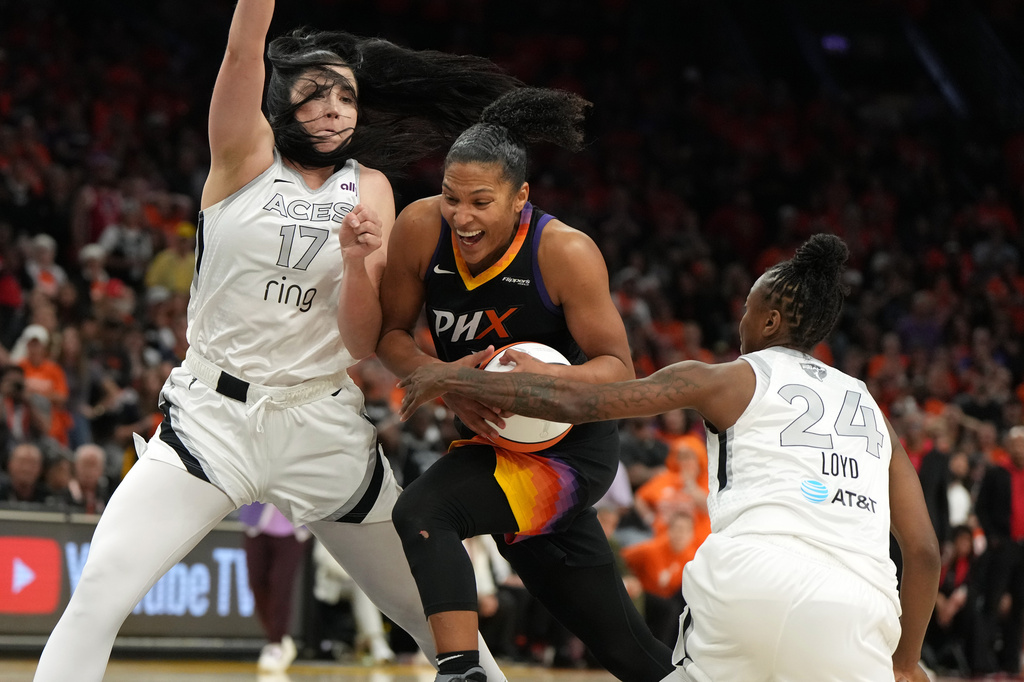 Phoenix Mercury forward Alyssa Thomas drives between Las Vegas Aces center Megan Gustafson and guard Jewell Loyd (24) during the second half of Game 3 of the WNBA basketball finals, Wednesday, Oct. 8, 2025, in Phoenix. (AP Photo/Rick Scuteri)