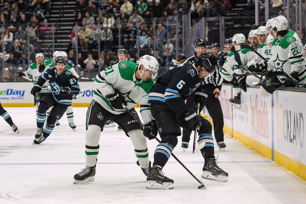 Dallas Stars left wing Jason Robertson, center left, fights for the puck against Utah Mammoth defenseman John Marino (6) during the second period of an NHL hockey game, Thursday, Jan. 15, 2026, in Salt Lake City. (AP Photo/Melissa Majchrzak)
