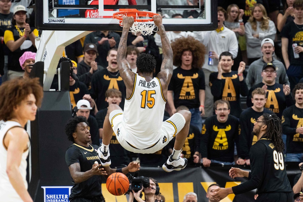 Missouri's Shawn Phillips Jr. (15) dunks over Vanderbilt's Mike James, left, and Devin McGlockton (99) during the first half of an NCAA college basketball game Wednesday, Feb. 18, 2026, in Columbia, Mo. (AP Photo/L.G. Patterson)
