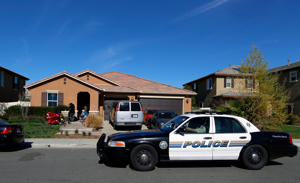FILE - A police car drives past the home of David and Louise Turpin, where police arrested the couple accused of holding their foster children captive, on Jan. 24, 2018, in Perris, Calif. (AP Photo/Damian Dovarganes, File)