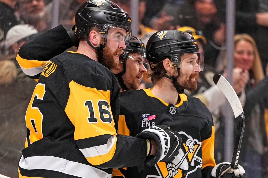 Pittsburgh Penguins' Egor Chinakhov, center, celebrates with Justin Brazeau, left, and Tommy Novak, right, after scoring against the Vegas Golden Knights during the second period of an NHL hockey game in Pittsburgh, Sunday, March 1, 2026. (AP Photo/Gene J. Puskar)