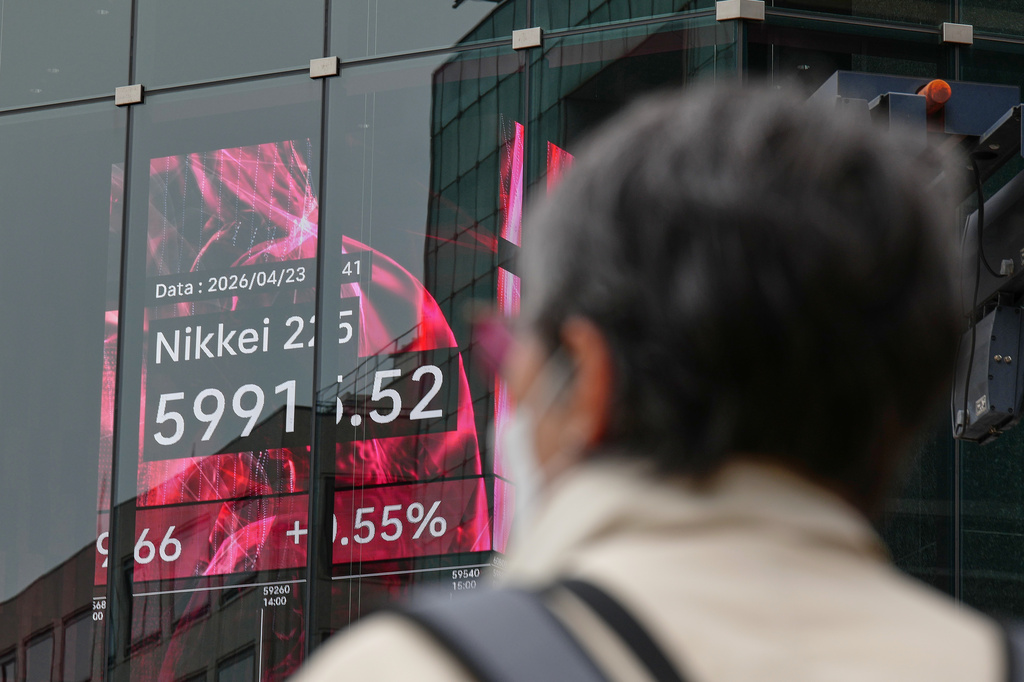 A person stands in front of an electronic stock board showing Japan's Nikkei index at a securities firm Thursday, April 23, 2026, in Tokyo. (AP Photo/Eugene Hoshiko)