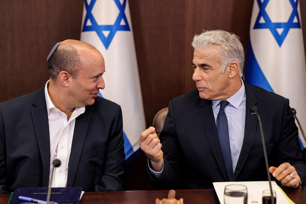 Israel's then caretaker Prime Minister Yair Lapid, right, talks with former Prime Minister Naftali Bennett during the weekly cabinet meeting in Jerusalem, on Sunday, Sept. 18, 2022. (Ronaldo Schemidt/Pool Photo via AP)