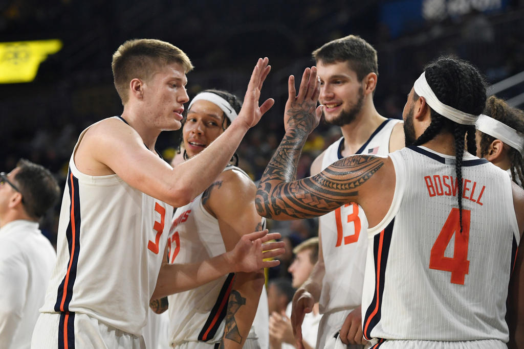 FILE - From left, Illinois' Ben Humrichous (3), Tre White, Tomislav Ivisic (13), and Kylan Boswell (4) congratulate one another near the end of the second half of an NCAA college basketball game against Michigan, Sunday, March 2, 2025, in Ann Arbor, Mich. (AP Photo/Jose Juarez, FIle