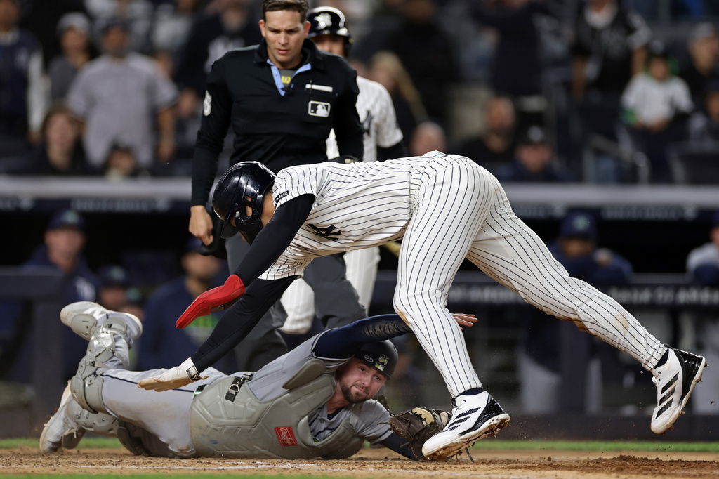 New York Yankees' George Lombard Jr. avoids a tag from Tampa Bay Rays catcher Liam Hicks to score a run during the seventh inning of a baseball game Thursday, Sept. 24, 2026, in New York. (AP Photo/Adam Hunger)