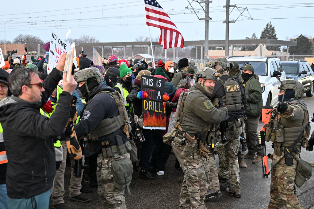 Protesters confront federal agents outside the Bishop Henry Whipple Federal Building, Thursday, Jan. 8, 2026, in Minneapolis, Minn. (AP Photo/Tom Baker)