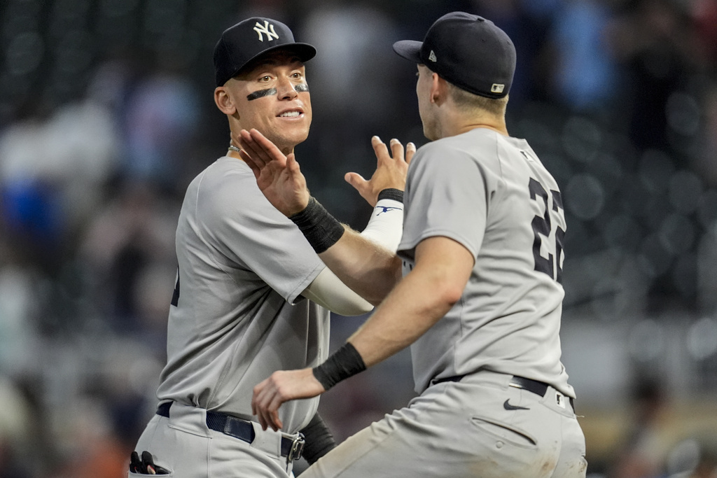 New York Yankees outfielder Aaron Judge (99) celebrates a win with Ben Rice (22) after a baseball game against the Minnesota Twins, Wednesday, Sept. 17, 2025, in Minneapolis. (AP Photo/Mike Stewart)