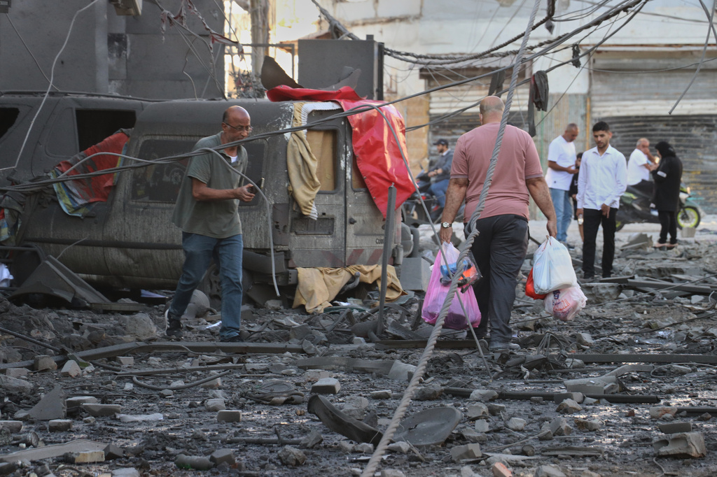 A man carries his belongings, as he leaves the site of destroyed buildings that were hit in Israeli airstrikes in the southern port city of Tyre, Lebanon, Thursday, May 28, 2026. (AP Photo)