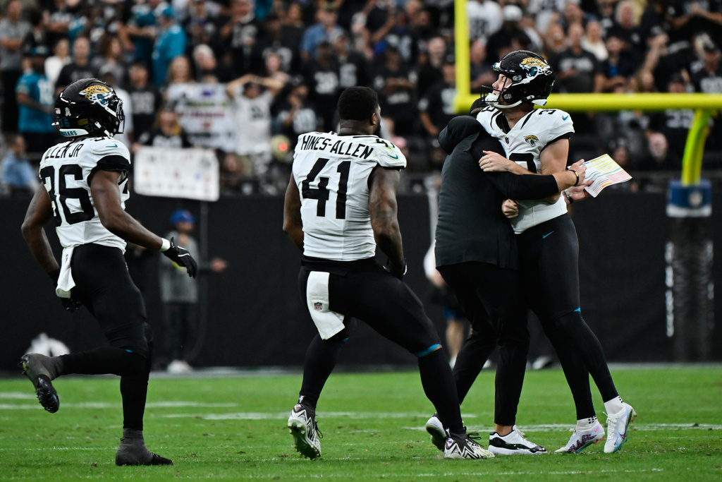 Jacksonville Jaguars place kicker Cam Little, from right, is congratulated by head coach Liam Coen after making a 68-yard field goal during the first half of an NFL football game, Sunday against the Las Vegas Raiders, Nov. 2, 2025, in Las Vegas. (AP Photo/David Becker)