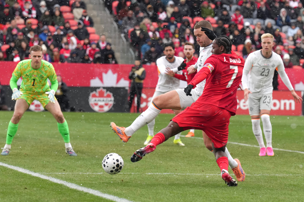 Canada's Jonathan David tries to square the ball despite pressure from Iceland's Sverrir Ingi Ingason during International friendly soccer action in Toronto on Saturday March 28, 2026. (Chris Young/The Canadian Press via AP)