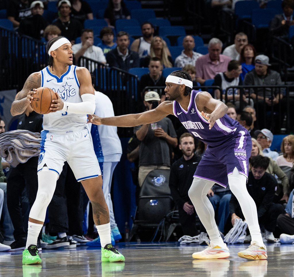 Orlando Magic forward Paolo Banchero (5) holds the ball against Sacramento Kings forward Precious Achiuwa (9) during the first half of an NBA basketball game, Thursday, March 26, 2026, in Orlando, Fla. (AP Photo/Willie J. Allen Jr.)