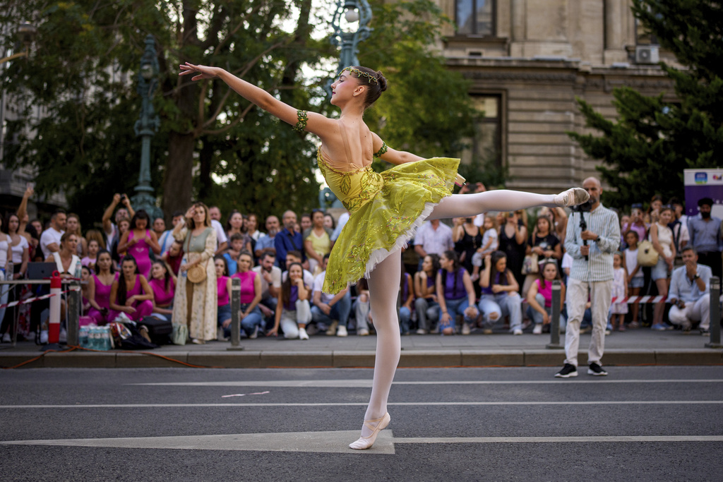 Daria Toma, 15, of the Romanian National Opera's Ballet Studio dances outside the National History Museum of Romania during Dance Night, an event featuring a wide variety of dance styles performed on the Calea Victoriei avenue in Bucharest, Romania, Saturday, Aug. 23, 2025. (AP Photo/Andreea Alexandru)