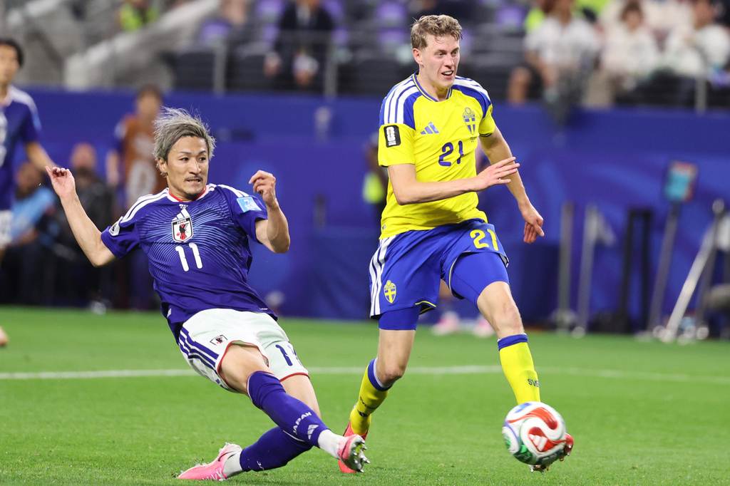 Japan's Daizen Maeda (11) scores his team's first goal as Sweden's Alexander Bernhardsson (21) watches during the World Cup Group F soccer match between Japan and Sweden in Arlington, Texas, near Dallas, Thursday, June 25, 2026. (AP Photo/Sam Hodde)
