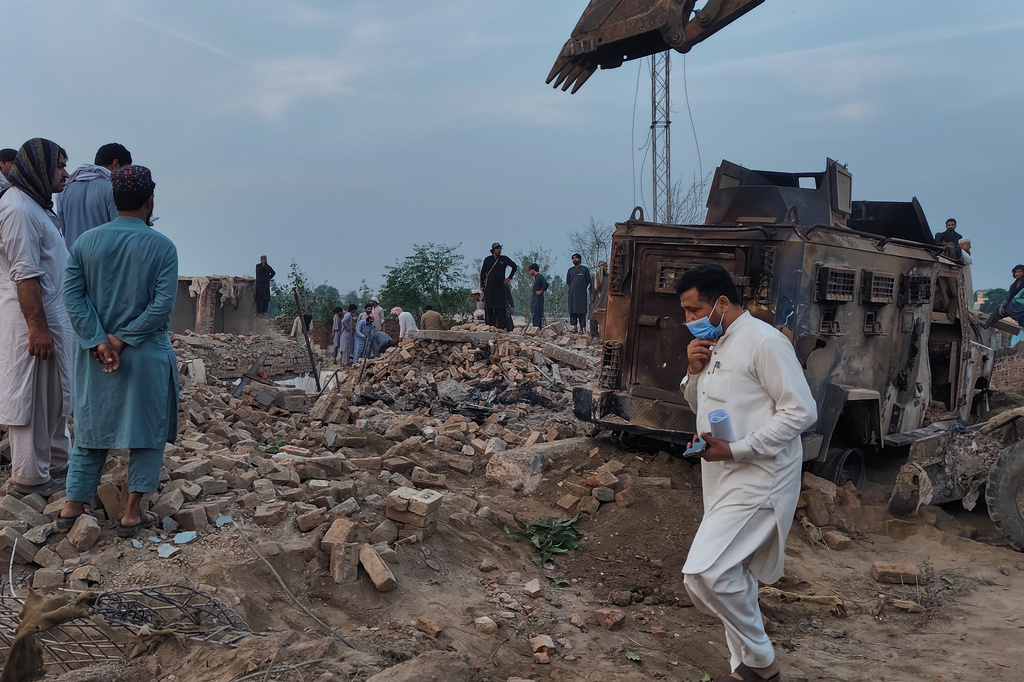 Police officers and local residents examine the site of overnight suicide bombing at a security post in Fatah Khel, in Bannu, a district in Pakistan's Khyber Pakhtunkhwa province bordering Afghanistan, Sunday, May 10, 2026. (AP Photo/Aamad Khattak)