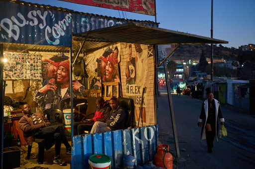 A woman passes a barber shop with men sitting inside at the end of the day in Maseru, Lesotho, July 18, 2025. (AP Photo/Bram Janssen) A woman passes a barber shop with men sitting inside at the end of the day in Maseru, Lesotho, July 18, 2025. (AP Photo/Bram Janssen)