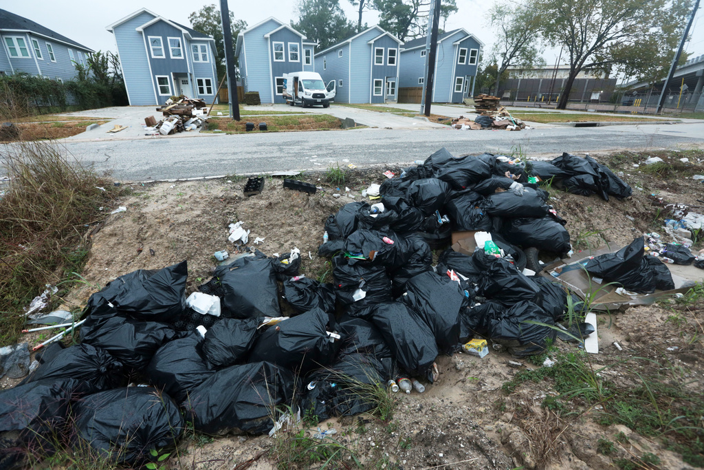 Piles of trash fill the ditch across a construction site in the Trinity Gardens neighborhood in northwest Houston, Thursday, Dec. 4, 2025. (AP Photo/Lekan Oyekanmi )