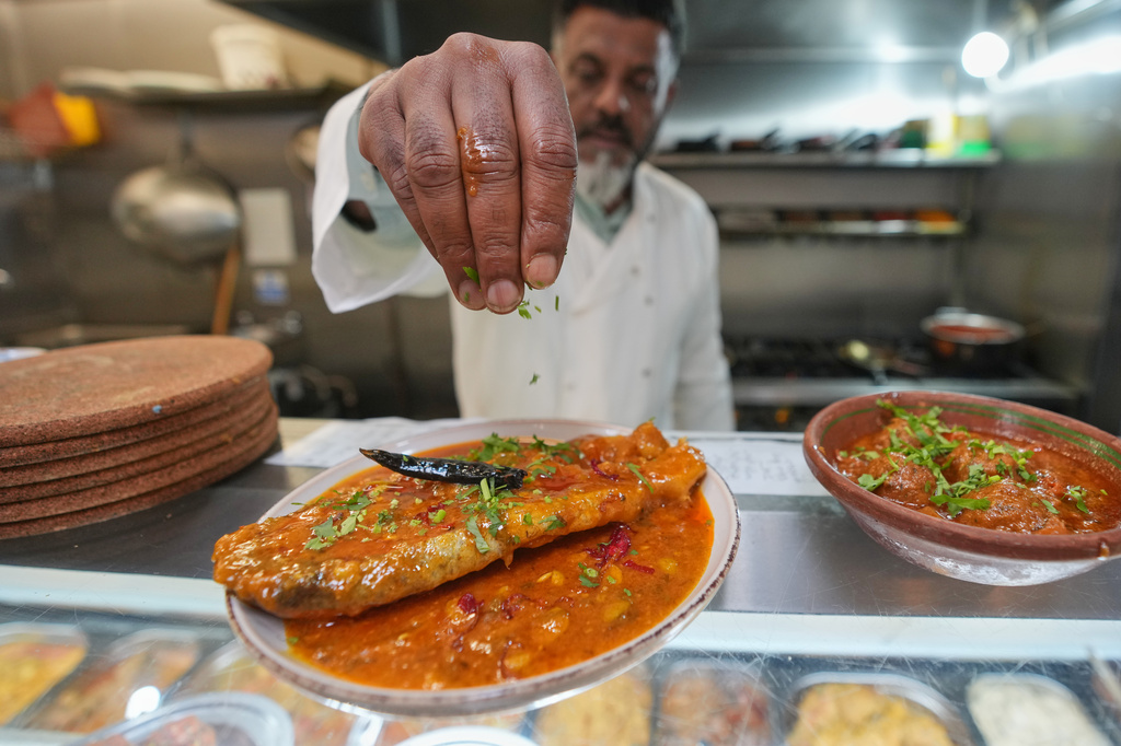Chef Mohammed Shanoor Ali prepares food at a Bangladeshi restaurant in London, Thursday, June 18, 2026. (AP Photo/Kin Cheung)