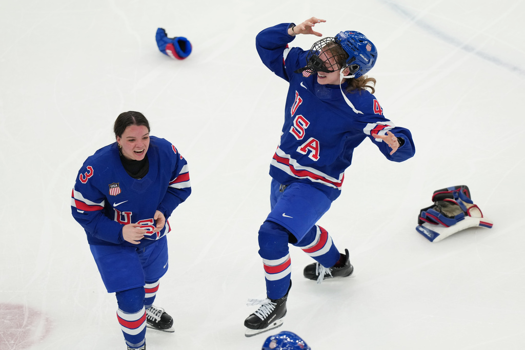 United States' Cayla Barnes (3) and Caroline Harvey (4) celebrate after beating Canada in overtime to win the women's ice hockey gold medal game at the 2026 Winter Olympics, in Milan, Italy, Thursday, Feb. 19, 2026. (AP Photo/Carolyn Kaster)