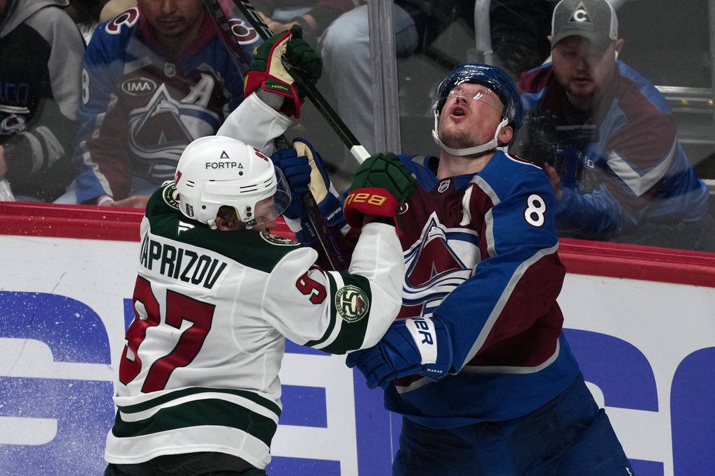 Minnesota Wild left wing Kirill Kaprizov, left, gets called for a high stick penalty as Colorado Avalanche defenseman Cale Makar reacts in the third period of Game 2 of an NHL hockey Stanley Cup second-round playoff series Tuesday, May 5, 2026, in Denver. (AP Photo/David Zalubowski)