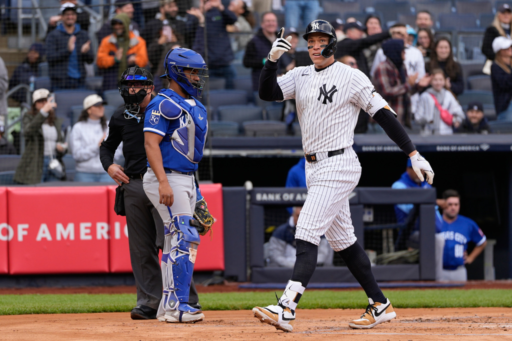 While Kansas City Royals catcher Elias Diaz, left, looks on, New York Yankees' Aaron Judge reacts after hitting a two-run homer during the first inning of a baseball game, Sunday, April 19, 2026, in New York. (AP Photo/Seth Wenig)