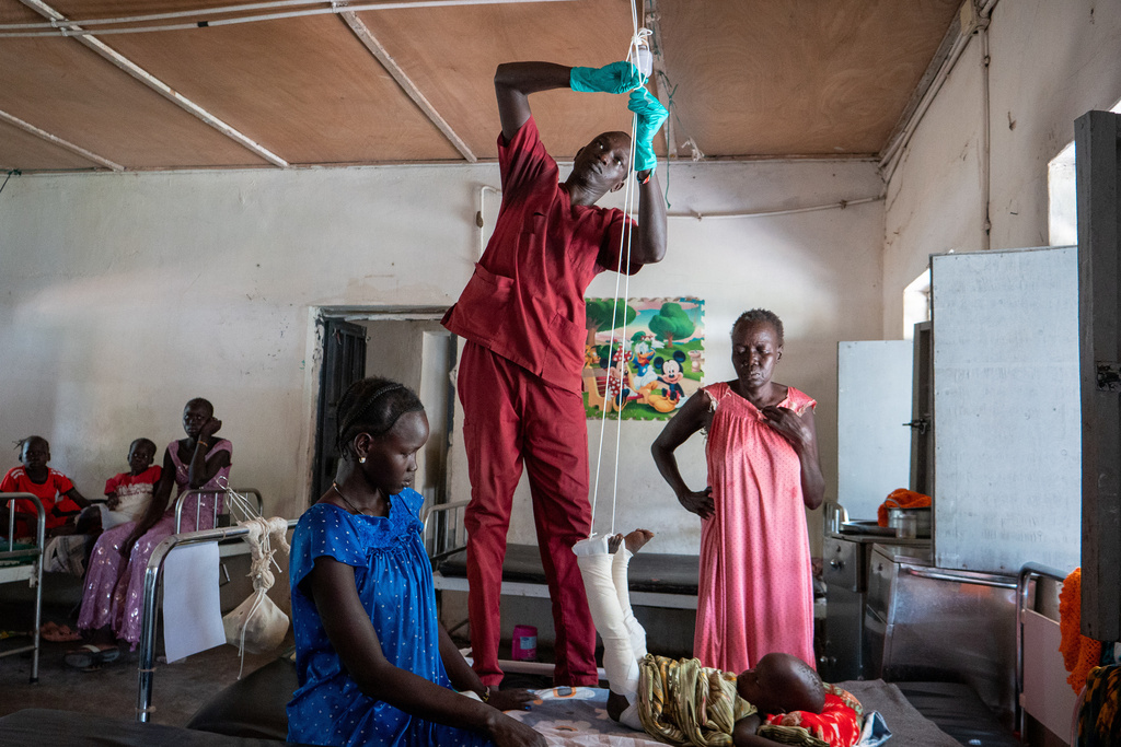 Nyayual Chuol, right, watches her 18-month-old grandson Kool Gatyen Pajock, who was shot during the conflict-hit state, receive treatment at the Akobo County Hospital in South Sudan, Saturday, Feb. 21, 2026. (AP Photo/Florence Miettaux)