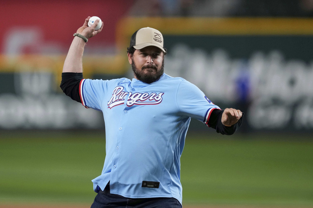 Actor Cole Hauser throws the ceremonial first pitch before a baseball game between the Cleveland Guardians and Texas Rangers Sunday, Aug. 24, 2025, in Arlington, Texas. (AP Photo/Tony Gutierrez)