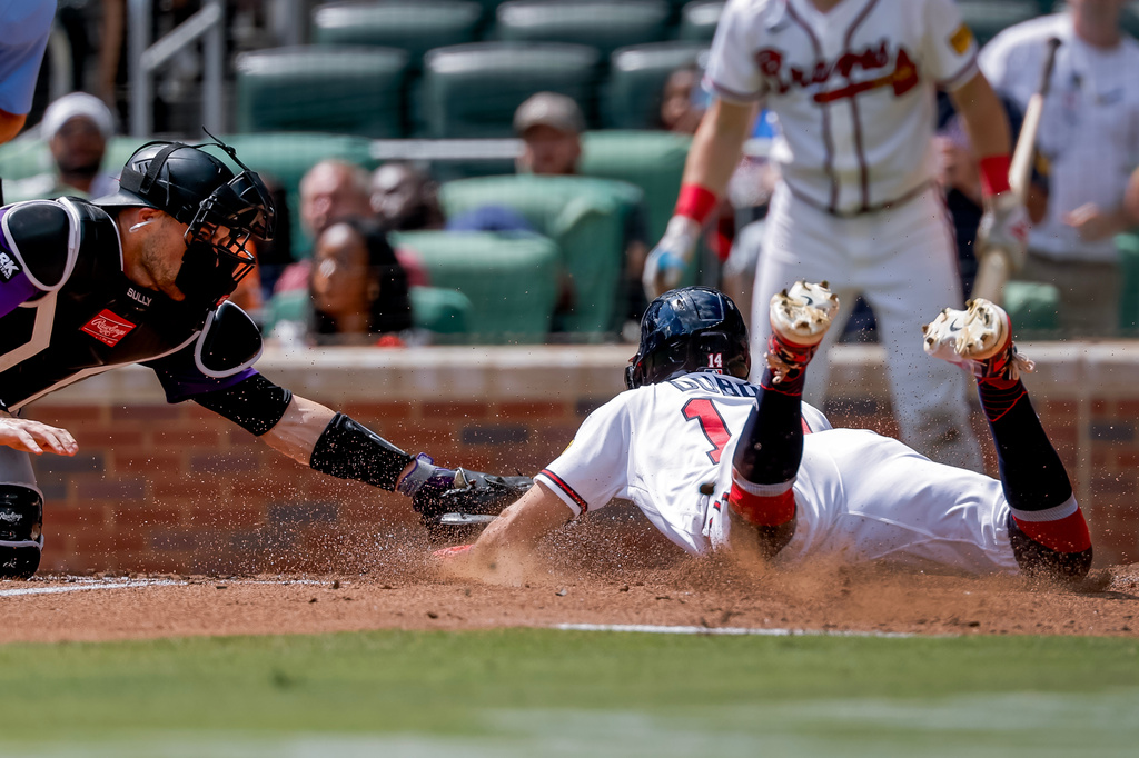 Colorado Rockies catcher Brett Sullivan, left, tags out Atlanta Braves' Mauricio Dubón, right, during the sixth inning of a baseball game, Sunday, Aug. 30, 2026, in Atlanta. (AP Photo/Erik S. Lesser)