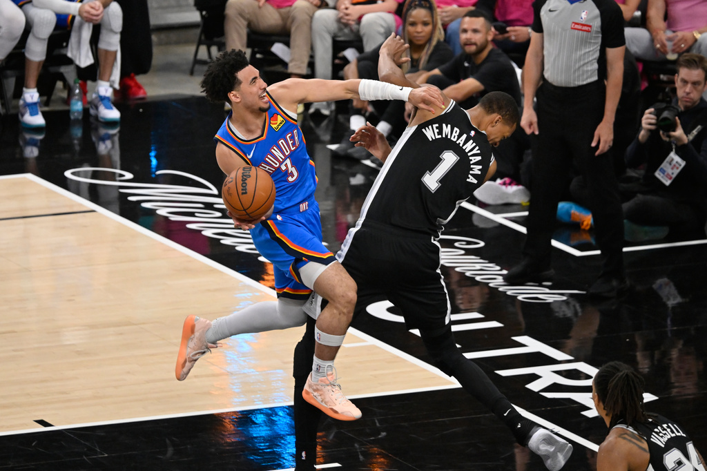 San Antonio Spurs forward Keldon Johnson (3) works toward the basket as San Antonio Spurs forward Victor Wembanyama (1) defends during the second half of Game 3 in the Western Conference finals NBA basketball playoffs series Friday, May 22, 2026, in San Antonio. (AP Photo/Darren Abate)