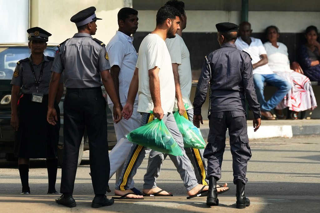 FILE -Two Iranian sailors, center, who were rescued from IRIS Dena warship by Sri Lanka's navy are escorted to a Judicial Medical Officer from the National Hospital, in Galle, Sri Lanka, March 5, 2026. (AP Photo/Eranga Jayawardena, File)