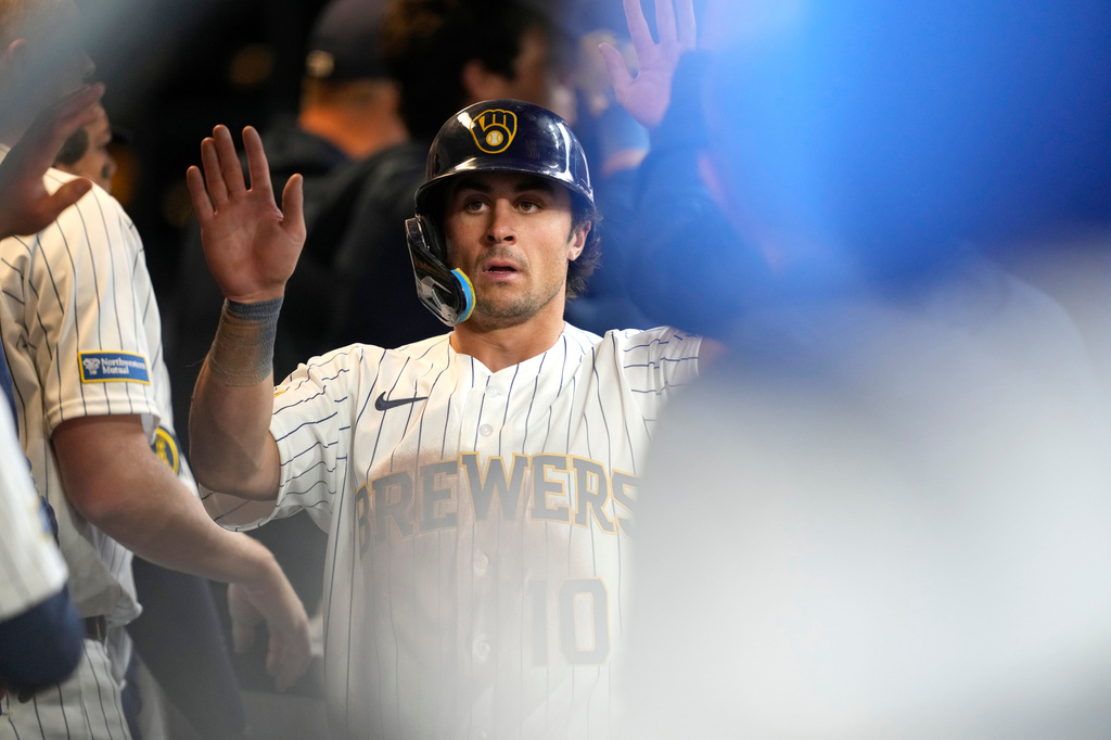 Milwaukee Brewers' Sal Frelick high-fives teammates after scoring on an RBI single hit by Brandon Lockridge during the sixth inning of a baseball game against the Chicago White Sox, Sunday, March 29, 2026, in Milwaukee. (AP Photo/Kayla Wolf)