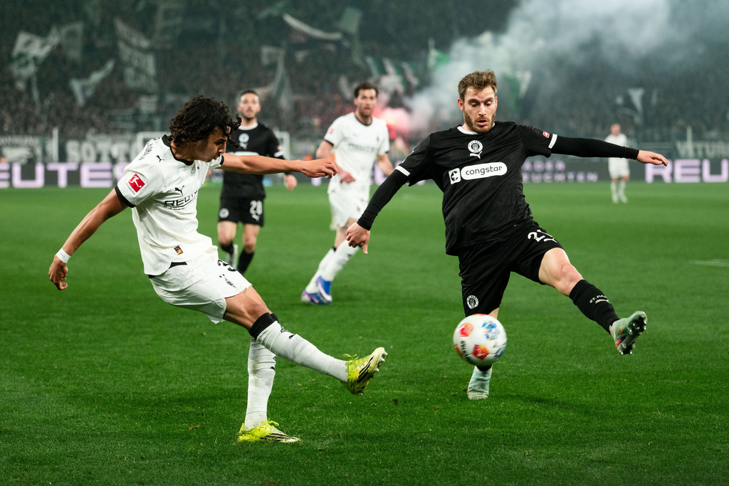 Mönchengladbach's Wael Mohya, left, and St. Pauli's Lars Ritzka in action during the Bundesliga soccer match between Borussia Mönchengladbach and FC St. Pauli in Mönchengladbach, Germany, Friday March 13, 2026. (Marius Becker/dpa via AP)