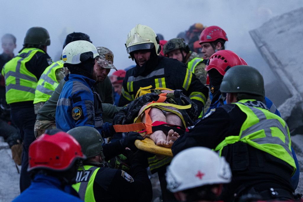 Rescue workers carry an injured woman on a stretcher from a house heavily damaged after a Russian strike on a residential neighborhood in Kyiv, Ukraine, on Thursday, May 14, 2026. (AP Photo/Evgeniy Maloletka)