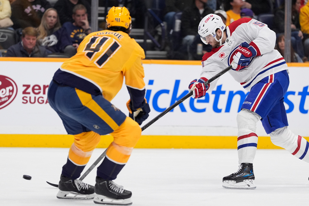 Montreal Canadiens defenseman Noah Dobson (53) shoots the puck past Nashville Predators defenseman Nicolas Hague (41) during the first period of an NHL hockey game Saturday, March 28, 2026, in Nashville, Tenn. (AP Photo/George Walker IV)