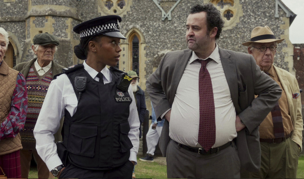This image released by Netflix shows Naomi Ackie, left, and Daniel Mays in a scene from "The Thursday Murder Club." (Netflix via AP)