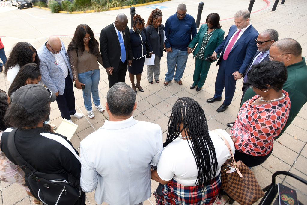 FILE - Descendants of Henrietta Lacks, whose cells, known as HeLa cells, have been used in medical research without her permission, say a prayer with attorneys outside the federal courthouse in Baltimore, Monday, Oct. 4, 2021. (AP Photo/Steve Ruark, File)