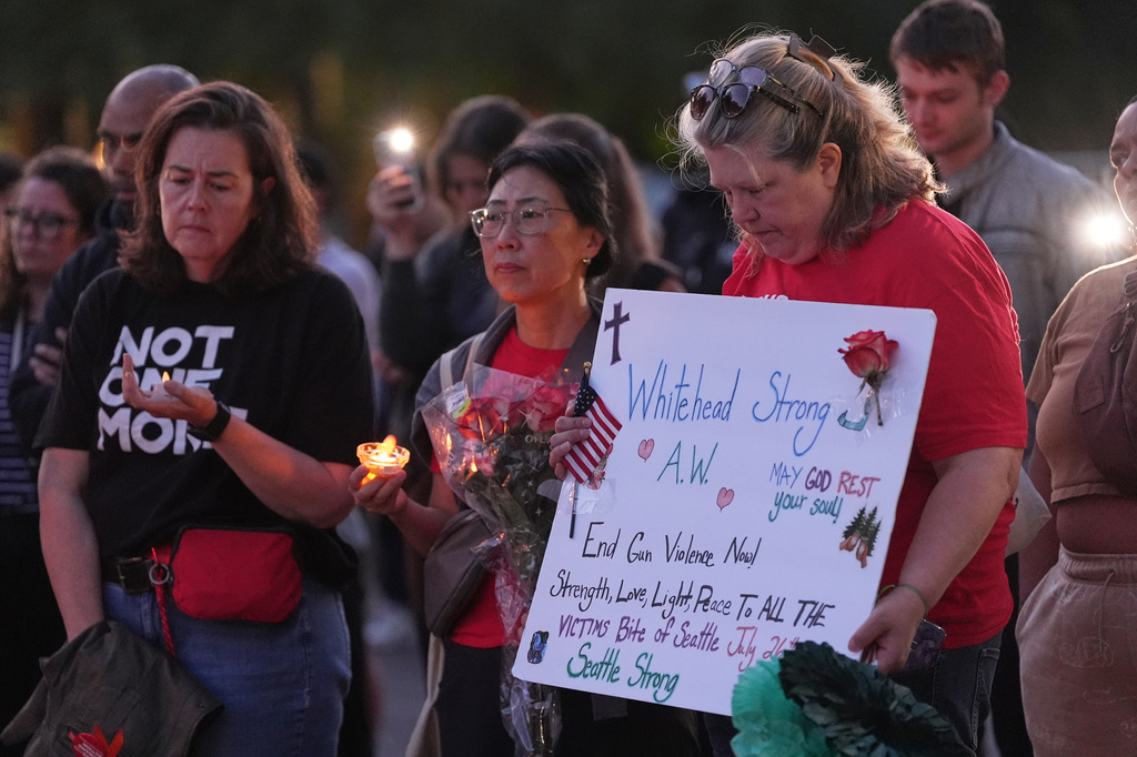 Michelle Whitehead, right, cousin of victim Ashley Whitehead, attends the vigil for victims the day after a shooting at Seattle Center during the Bite of Seattle food festival, Monday, July 27, 2026, in Seattle. (AP Photo/Lindsey Wasson)