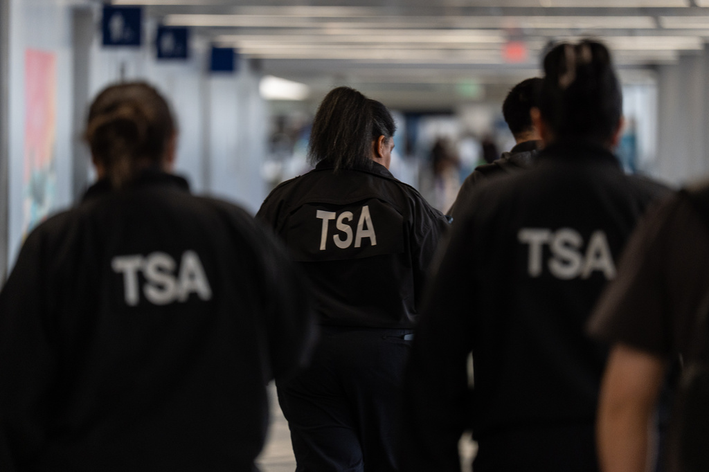 TSA agents walk through a terminal at Los Angeles International Airport in Los Angeles, Friday, March 27, 2026. (AP Photo/Jae C. Hong)