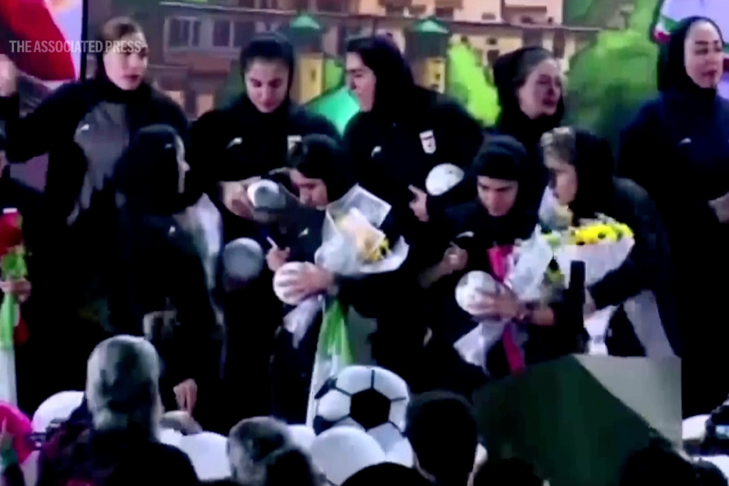 Members of Iran's national women's soccer team autograph soccer balls during a welcome ceremony upon their return to the Islamic Republic in Tehran, Thursday, March 19, 2026. (Iran Press via AP)