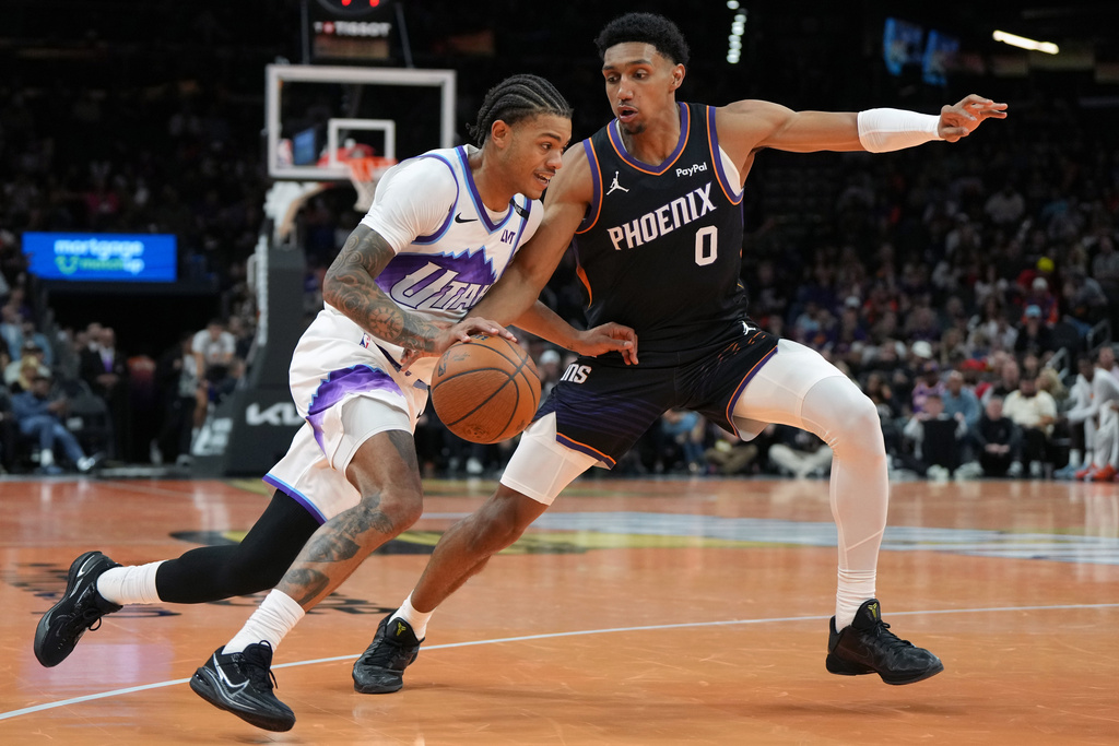 Utah Jazz guard Keyonte George drives on Phoenix Suns forward Ryan Dunn (0) during the second half of an NBA Cup basketball game, Friday, Oct. 31, 2025, in Phoenix. (AP Photo/Rick Scuteri)