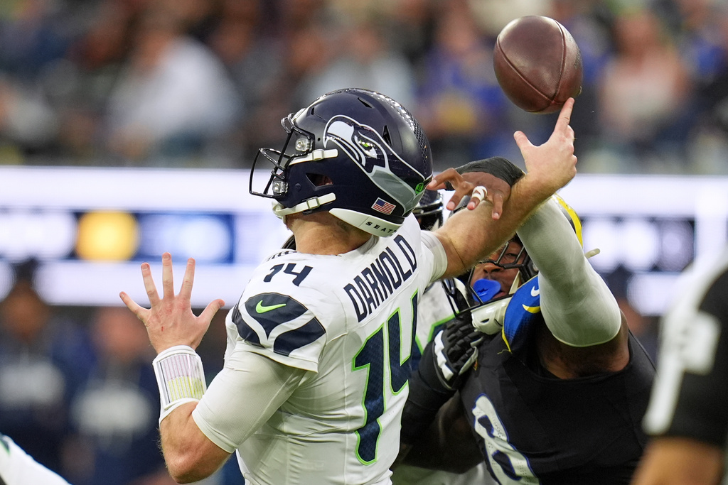 Seattle Seahawks quarterback Sam Darnold, left, is hit by Los Angeles Rams linebacker Jared Verse for an incomplete pass during the second half of an NFL football game Sunday, Nov. 16, 2025, in Inglewood, Calif. (AP Photo/Gregory Bull)