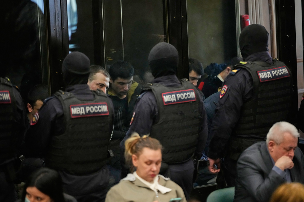 Men tried on the charges of involvement in a terror attack at the Crocus City Hall in March 2024 listen to the verdict in a glass cage at the Second Western District Military Court in Moscow, Russia, Thursday, March 12, 2026. (AP Photo/Pavel Bednyakov)