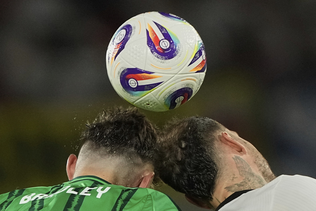 Northern Ireland's Conor Bradley, left, and Germany's David Raum reach for a header during the FIFA World Cup Group A qualifying soccer match between Germany and Northern Ireland at RheinEnergieStadion stadium in Cologne, Germany, Sunday, Sept. 7, 2025 (AP Photo/Martin Meissner)