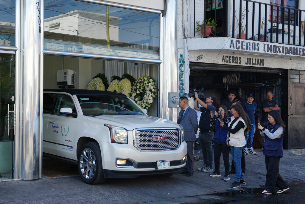 Journalists take photos and videos of a car carrying the remains of who authorities identified as the late Jalisco New Generation Cartel leader Nemesio Oseguera, alias "El Mencho," to Recinto de Paz cemetery in Guadalajara, Mexico, Monday, March 2, 2026. (AP Photo/Refugio Ruiz)