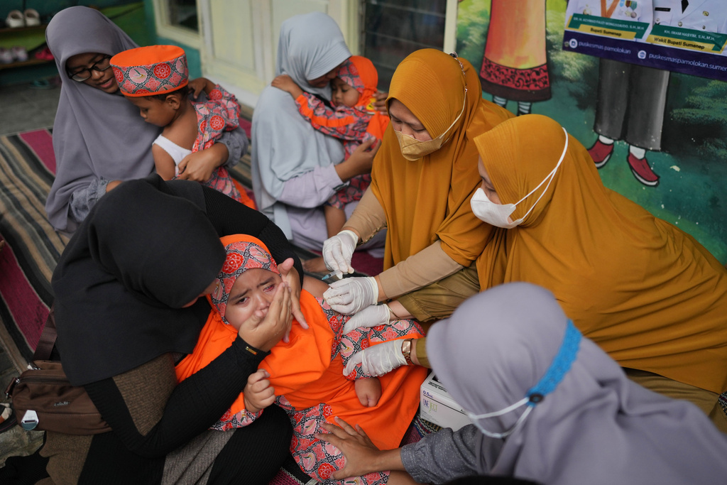 Health workers administer a measles shot to a child during a vaccination campaign following an outbreak, at a kindergarten in Sumenep on Madura Island, Indonesia, Monday, Sept. 8, 2025. (AP Photo/Dita Alangkara)