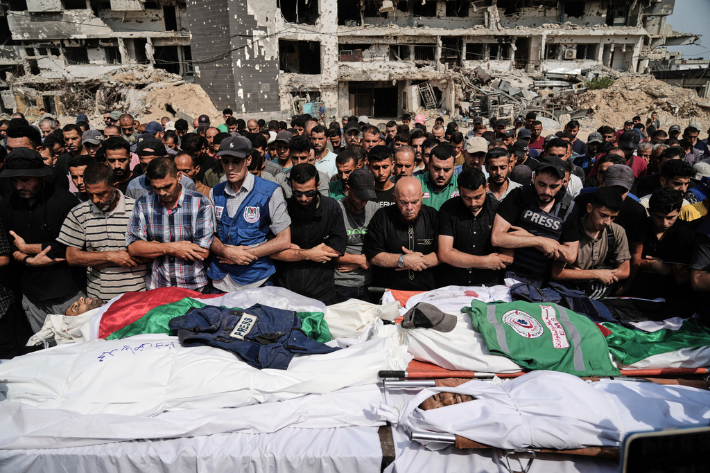 FILE - Palestinians pray over the bodies of journalists, including Al Jazeera correspondents Anas al-Sharif and Mohamed Qreiqeh, who were killed in an Israeli airstrike, during their funeral outside Gaza City's Shifa hospital complex, Monday, Aug. 11, 2025. (AP Photo/Jehad Alshrafi, File)