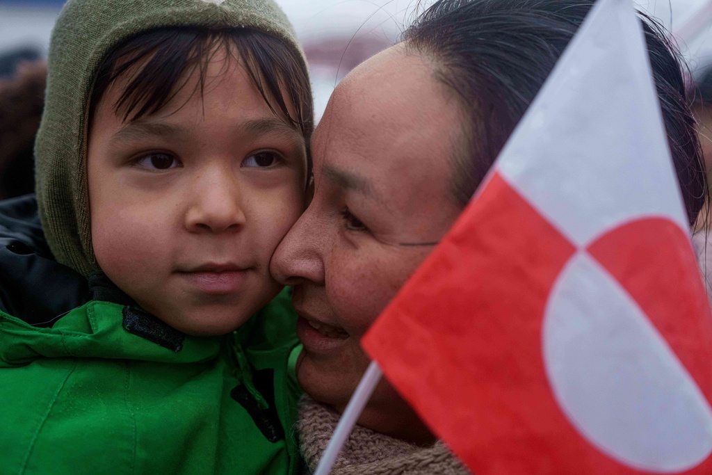 An Inuit woman holds her child during a protest against Trump's policy towards Greenland in front of the US consulate in Nuuk, Greenland, Saturday, Jan. 17, 2026. (AP Photo/Evgeniy Maloletka)