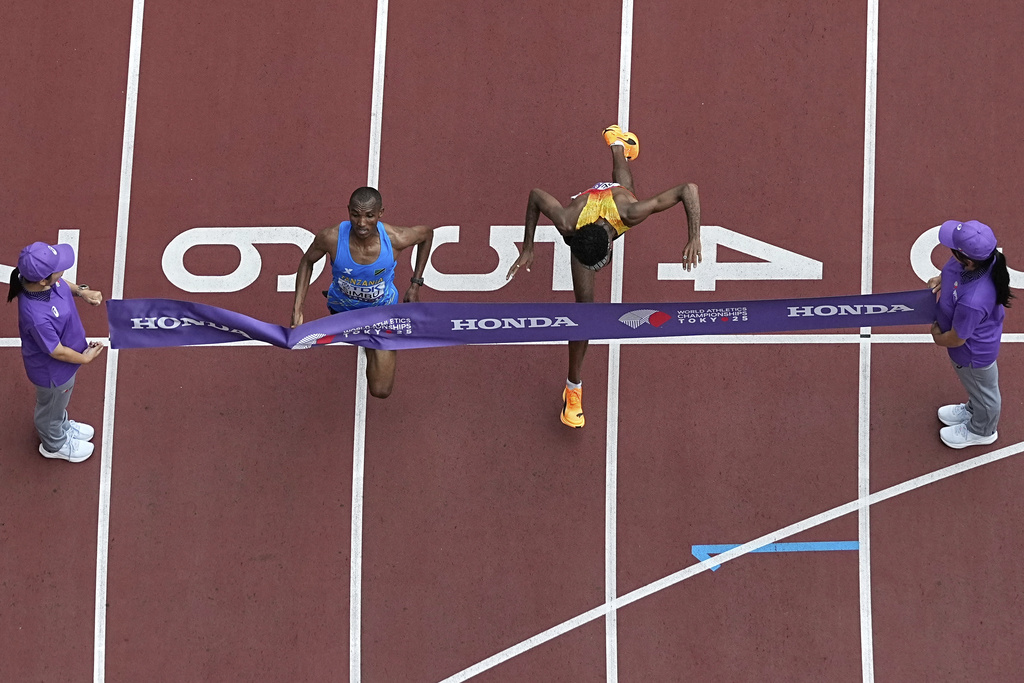 Tanzania's Alphonce Felix Simbu, left, crosses the finish line ahead of Germany's Amanal Petros to win the men's marathon at the World Athletics Championships in Tokyo, Monday, Sept. 15, 2025. (AP Photo/Bernat Armangue)