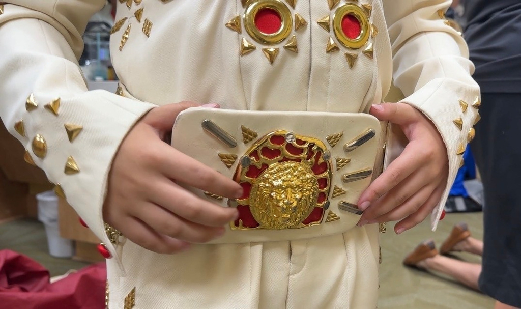 In this screenshot from video, Gibbs Jones, 11, rests his hands on a jeweled belt while showing off his costume for the Tupelo Elvis Festival's youth tribute artists competition on June 4, 2026, in Tupelo, Miss. (AP Photo/Sophie Bates)